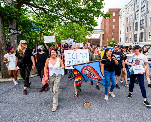 People march holding a banner of Our Lady of Guadalupe and signs on Thursday, June 12, 2025, during a protest near Five 10 Flats in South Side Bethlehem. The protest was organized by Lehigh Valley Immigration Emergency Response Network. (April Gamiz/The Morning Call)