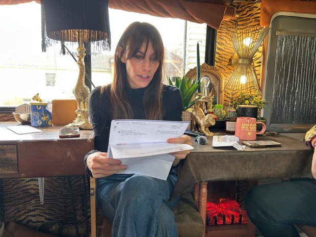 Charlie Miller of Perry Township looks at medical bills for $21,000 in rabies treatment. She is uninsured. A discount left her with about $5,450 to pay. (Hanna Holthaus / Spotlight PA)