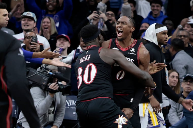 Sixers Tyrese Maxey is lifted up by teammate Adem Bona after the Sixers won the Golden State Warriors at Philadelphia 76ers NBA game at Xfinity Mobile Arena in Philadelphia on Thursday, Dec. 4, 2025.