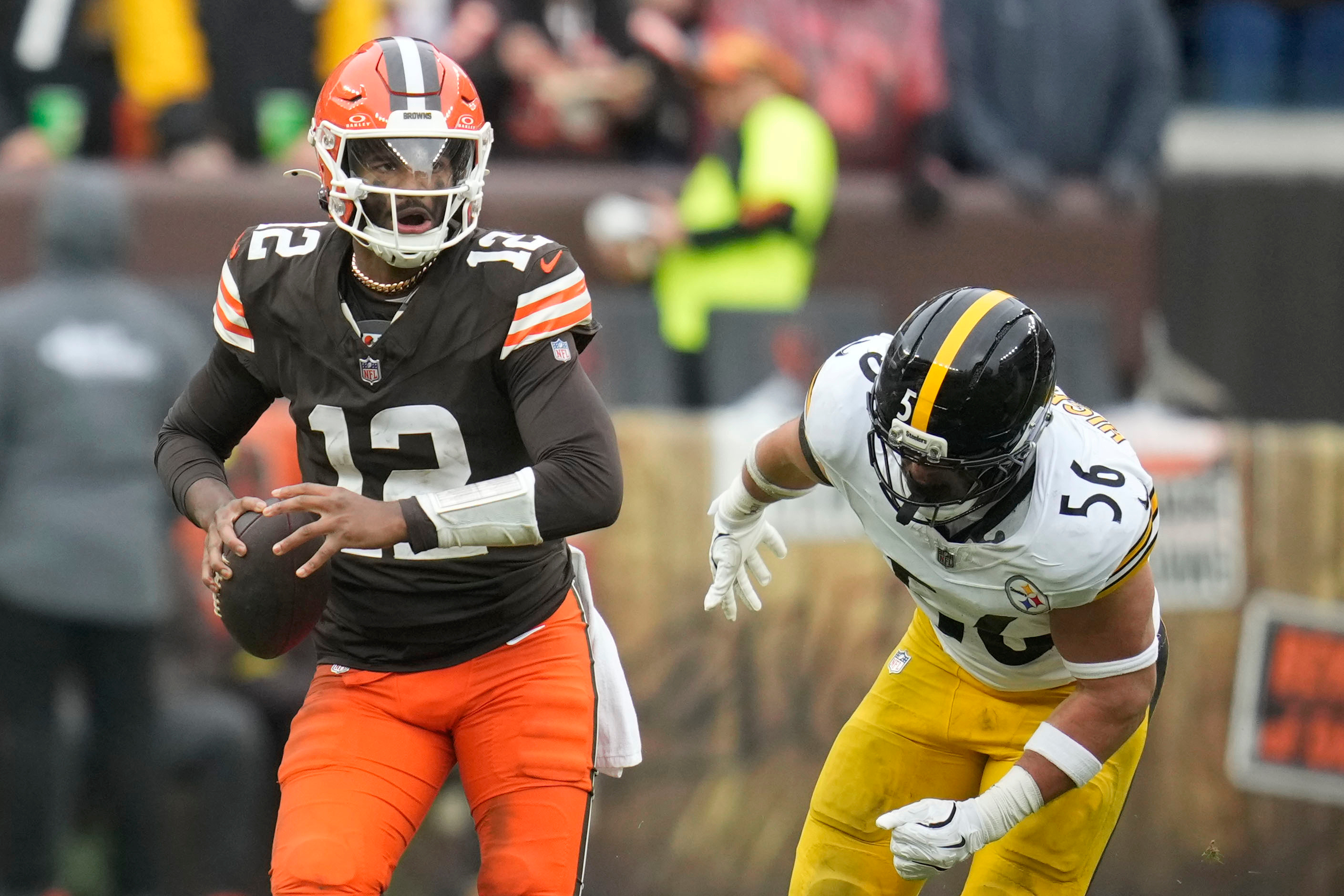Cleveland Browns quarterback Shedeur Sanders (12) runs from Pittsburgh Steelers linebacker Alex Highsmith (56) during the second half of an NFL football game, Sunday, Dec. 28, 2025, in Cleveland.