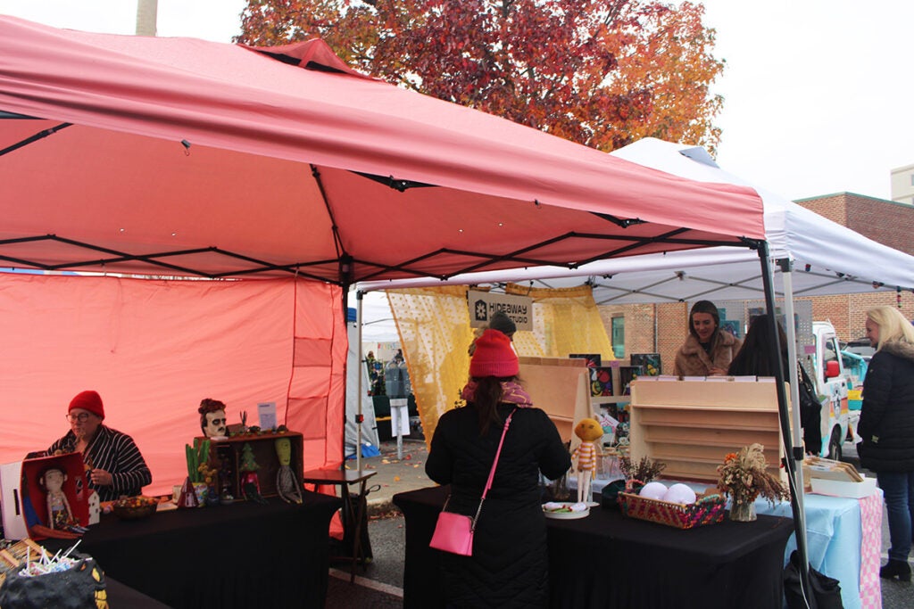 People shop in an outdoor tent in Ardmore, Pennsylvania