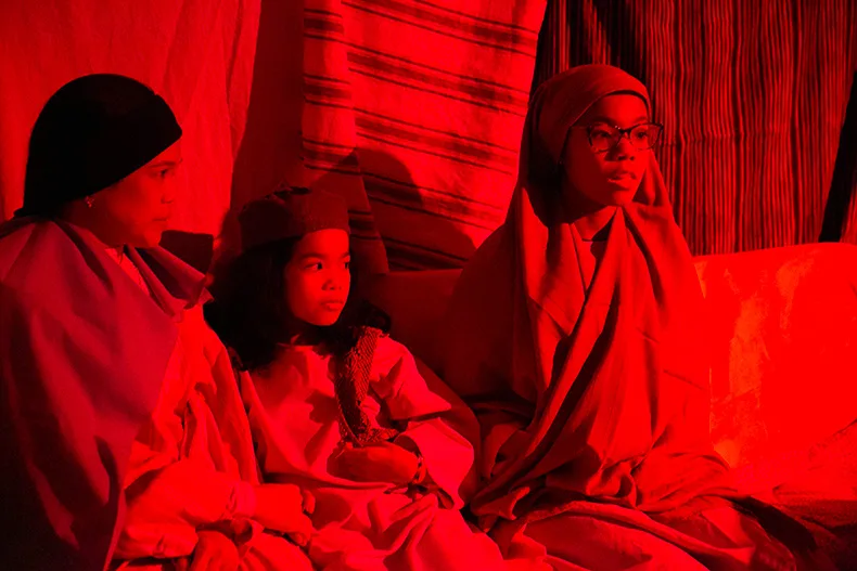 A family awaits a room and hears of the new king at the inn. Photo credit Juliana Garcia. 