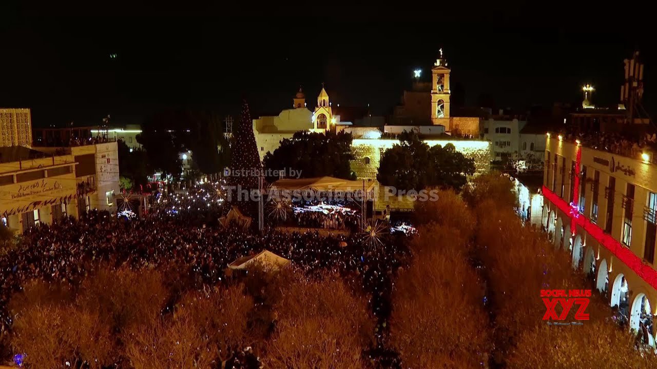 Hundreds flock to see Bethlehem Christmas tree lit up for first time since start of Gaza war (Video)