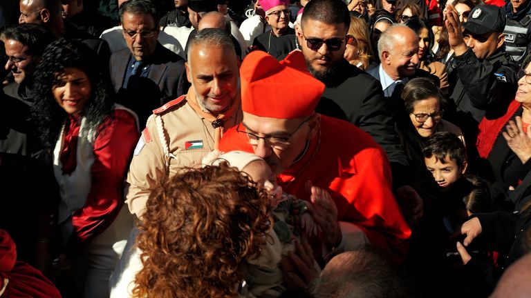 Latin Patriarch of Jerusalem, Cardinal Pierbattista Pizzaballa kisses babies in the crowd