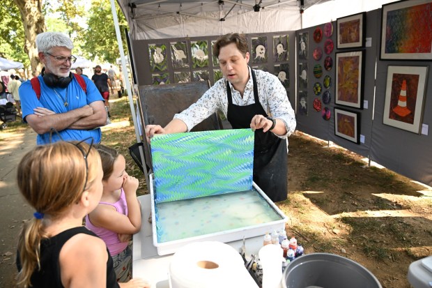 Artist Keith Garubba demonstrates how to create a painting featuring the marbling paint technique during the 50th Art in the Park event Saturday, Sept. 13, 2025, at West Park in Allentown. Established in 1971, Art in the Park celebrates the work of artists from the Lehigh Valley and beyond in Allentown's oldest park. About 130 artists exhibit and sell original ceramics, drawings, glass, jewelry, paintings, photography, sculpture, weaving, and art made from recycled or re-purposed materials. (Amy Shortell/The Morning Call)