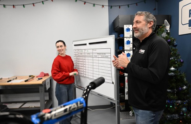 Gene Kaschak gives directions while Danielle Kennon takes notes on the board during the Manufacturers Resource Center's annual Santa's Standard Workshop on Wednesday, Dec. 10, 2025, in Upper Macungie Township. Workers from Just Born, Lutron, Northeast Products & Services and Ocean Spray came together to assemble bicycles for Community Bike Works youth while learning lean manufacturing principles. (Amy Shortell/The Morning Call)