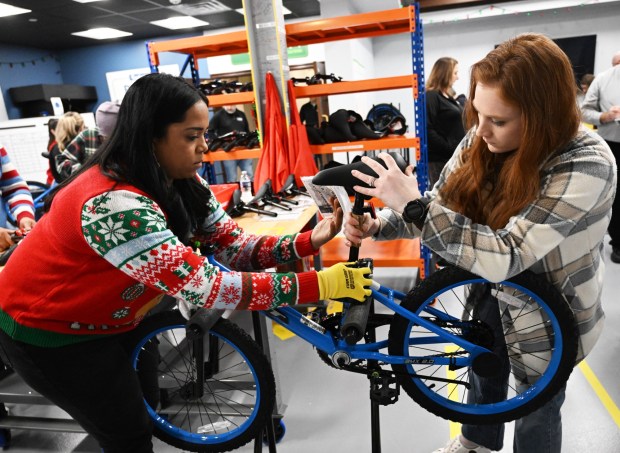 Katrina Seymour,left, and Emily Flores volunteer to build a bike during the Manufacturers Resource Center's annual Santa's Standard Workshop on Wednesday, Dec. 10, 2025, in Upper Macungie Township. Workers from Just Born, Lutron, Northeast Products & Services and Ocean Spray came together to assemble bikes for Community Bike Works youth while learning lean manufacturing principles. (Amy Shortell / The Morning Call)