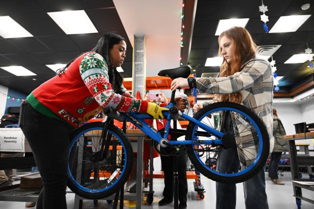 Katrina Seymour,left, and Emily Flores volunteer to build a bike during the Manufacturers Resource Center's annual Santa's Standard Workshop on Wednesday, Dec. 10, 2025, in Upper Macungie Township. Workers from Just Born, Lutron, Northeast Products & Services and Ocean Spray came together to assemble bikes for Community Bike Works youth while learning lean manufacturing principles. (Amy Shortell / The Morning Call)