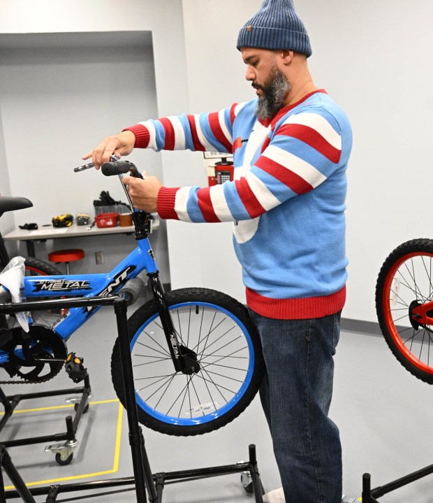 Thomas Santiago volunteers to build a bike during the Manufacturers Resource Center's annual Santa's Standard Workshop on Wednesday, Dec. 10, 2025, in Upper Macungie Township. Workers from Just Born, Lutron, Northeast Products & Services and Ocean Spray came together to assemble bikes for Community Bike Works youth while learning lean manufacturing principles. (Amy Shortell / The Morning Call)