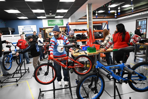 Thomas Santiago volunteers to build a bike during the Manufacturers Resource Center's annual Santa's Standard Workshop on Wednesday, Dec. 10, 2025, in Upper Macungie Township. Workers from Just Born, Lutron, Northeast Products & Services and Ocean Spray came together to assemble bikes for Community Bike Works youth while learning lean manufacturing principles. (Amy Shortell / The Morning Call)