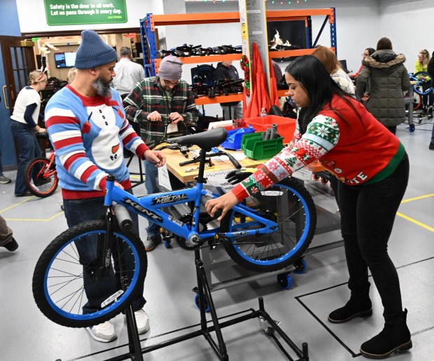 Thomas Santiago and Katrina Seymour volunteers to build a bike during the Manufacturers Resource Center's annual Santa's Standard Workshop on Wednesday, Dec. 10, 2025, in Upper Macungie Township. Workers from Just Born, Lutron, Northeast Products & Services and Ocean Spray came together to assemble bikes for Community Bike Works youth while learning lean manufacturing principles. (Amy Shortell / The Morning Call)