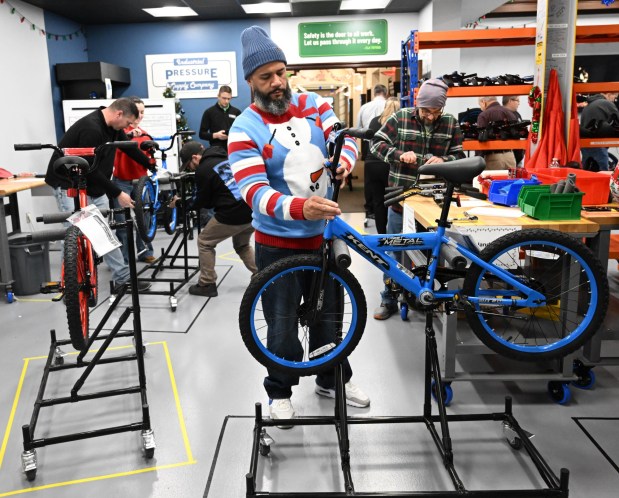 Thomas Santiago volunteers to build a bike during the Manufacturers Resource Center's annual Santa's Standard Workshop on Wednesday, Dec. 10, 2025, in Upper Macungie Township. Workers from Just Born, Lutron, Northeast Products & Services and Ocean Spray came together to assemble bikes for Community Bike Works youth while learning lean manufacturing principles. (Amy Shortell / The Morning Call)