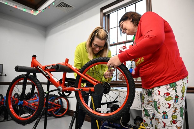 Rachel Vega and Cheryl Galan volunteer to build a bike during the Manufacturers Resource Center's annual Santa's Standard Workshop on Wednesday, Dec. 10, 2025, in Upper Macungie Township. Workers from Just Born, Lutron, Northeast Products & Services and Ocean Spray came together to assemble bikes for Community Bike Works youth while learning lean manufacturing principles. (Amy Shortell / The Morning Call)