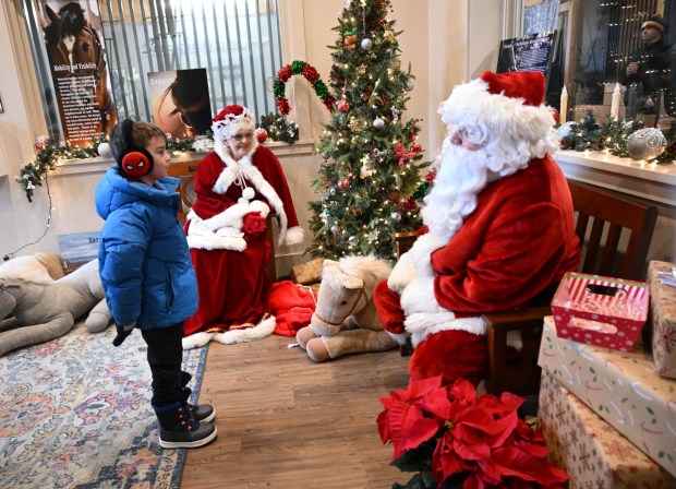 Jameson McCauley,7, of Bethlehem, greets Santa and Mrs. Claus during the Holiday with the Horses open house Sunday, Dec. 7, 2025, at the Bethlehem mounted police unit's barn. (Amy Shortell/The Morning Call)