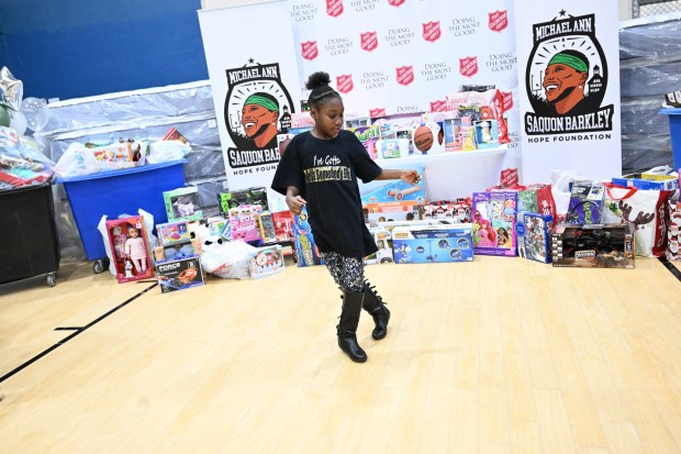 Jade Jenkins dances in front of a display of toys and mattresses Monday, Dec. 22, 2025, at the Salvation Army in Allentown. The Michael Ann and Saquon Barkley Hope Foundation, Salvation Army and Ashley's Furniture joined to donate beds, mattresses and toys to Lehigh Valley families in need, including some whose homes were burned in recent fires. (Amy Shortell/The Morning Call)