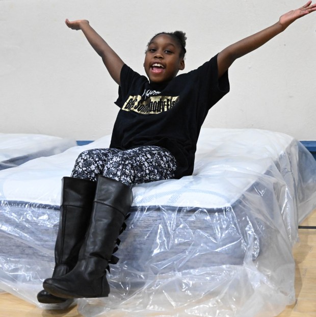 Jade Jenkins tries out a new mattress Monday, Dec. 22, 2025, at the Salvation Army in Allentown. The Michael Ann and Saquon Barkley Hope Foundation, Salvation Army and Ashley's Furniture joined to donate beds, mattresses and toys to Lehigh Valley families in need, including some whose homes were burned in recent fires. (Amy Shortell/The Morning Call)