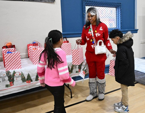 Tonya Johnson, All-Pro running back Saquon Barkley's mom and vice president of the Michael Ann and Saquon Barkley Hope Foundation, hands out toys to children Monday, Dec. 22, 2025, at the Salvation Army in Allentown. The foundation, Salvation Army and Ashley's Furniture joined to donate beds, mattresses and toys to Lehigh Valley families in need, including some whose homes were burned in recent fires. (Amy Shortell/The Morning Call)