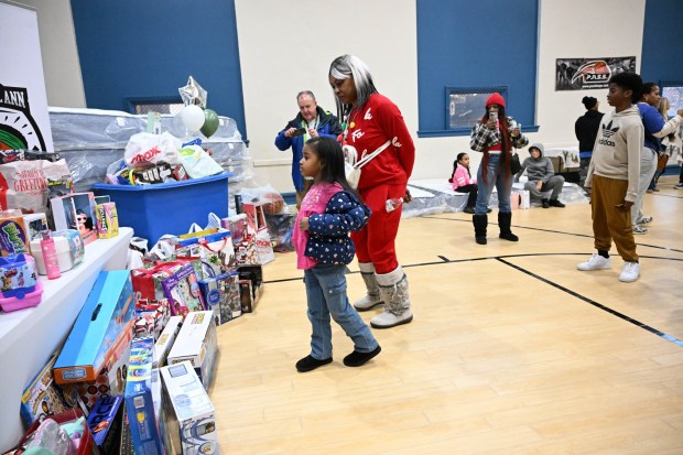 Tonya Johnson, All-Pro running back Saquon Barkley's mom and vice president of the Michael Ann and Saquon Barkley Hope Foundation, hands out toys to children Monday, Dec. 22, 2025, at the Salvation Army in Allentown. The foundation, Salvation Army and Ashley's Furniture joined to donate beds, mattresses and toys to Lehigh Valley families in need, including some whose homes were burned in recent fires. (Amy Shortell/The Morning Call)