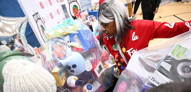 Tonya Johnson, All-Pro running back Saquon Barkley's mom and vice president of the Michael Ann and Saquon Barkley Hope Foundation, hands out toys to children Monday, Dec. 22, 2025, at the Salvation Army in Allentown. The foundation, Salvation Army and Ashley's Furniture joined to donate beds, mattresses and toys to Lehigh Valley families in need, including some whose homes were burned in recent fires. (Amy Shortell/The Morning Call)