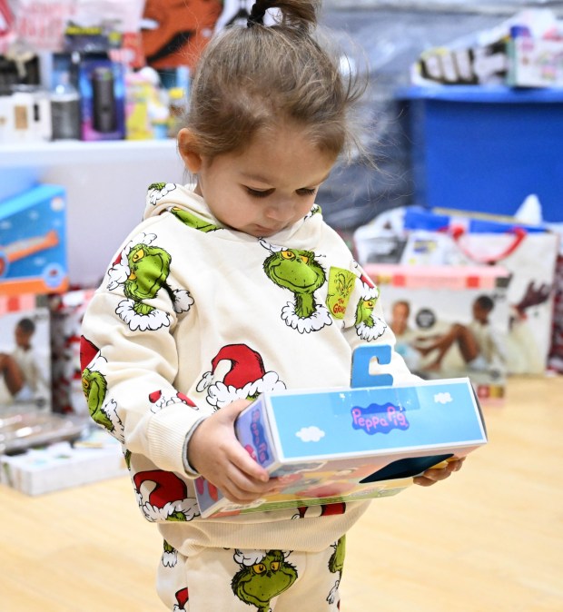 Archie Merced, 3, of Allentown shows off a Pepa Pig toy he selected Monday, Dec. 22, 2025, at the Salvation Army in Allentown. The Michael Ann and Saquon Barkley Hope Foundation, Salvation Army and Ashley's Furniture joined to donate beds, mattresses and toys to Lehigh Valley families in need, including some whose homes were burned in recent fires. (Amy Shortell/The Morning Call)