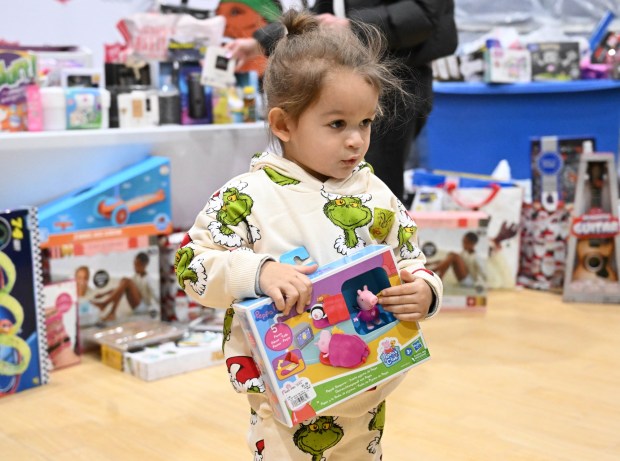 Archie Merced, 3, of Allentown shows off a Pepa Pig toy he selected Monday, Dec. 22, 2025, at the Salvation Army in Allentown. The Michael Ann and Saquon Barkley Hope Foundation, Salvation Army and Ashley's Furniture joined to donate beds, mattresses and toys to Lehigh Valley families in need, including some whose homes were burned in recent fires. (Amy Shortell/The Morning Call)