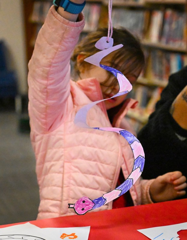 Diyana Cameron works on a spiral snake as part of a a Lunar New Year craft Wednesday, Jan. 29, 2025, at Emmaus Public Library. The library held a celebration featuring colorful books and crafts to mark the start of the Year of the Snake. (Amy Shortell/The Morning Call)