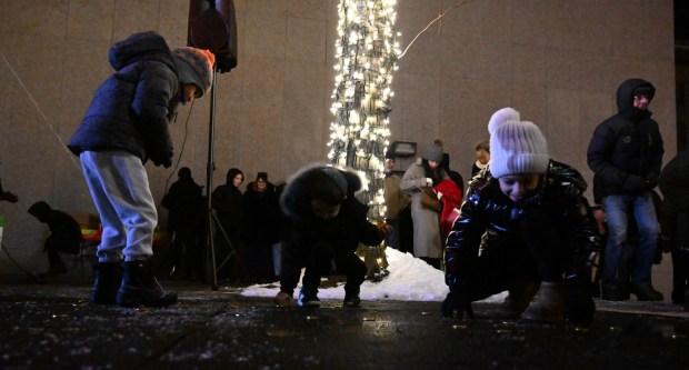 Children scramble to gather chocolate gold coins, known as gelt, Monday, Dec. 15, 2025, during a Hanukkah menorah lighting at Payrow Plaza in Bethlehem. Monday was the second night of the eight-day Jewish Festival of Lights. (Amy Shortell/The Morning Call)