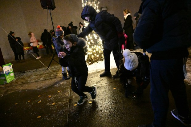 Children scramble to gather chocolate gold coins, known as gelt, Monday, Dec. 15, 2025, during a Hanukkah menorah lighting at Payrow Plaza in Bethlehem. Monday was the second night of the eight-day Jewish Festival of Lights. (Amy Shortell/The Morning Call)
