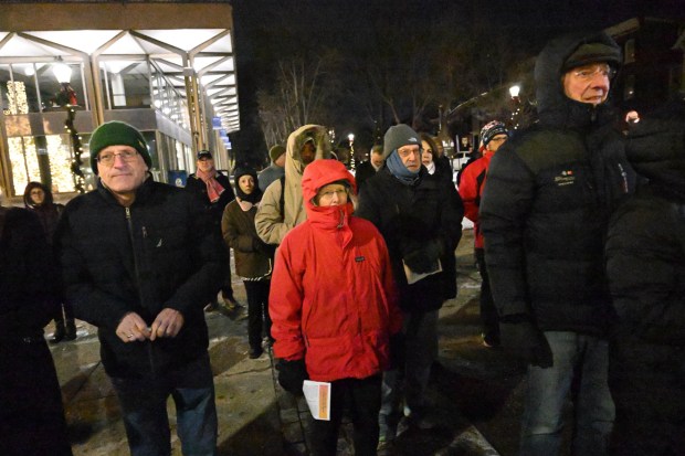 The crowd watches as Rabbi Yaacov Halperin and Bethlehem firefighters light three candles Monday, Dec. 15, 2025, on a Hanukkah menorah at Payrow Plaza in Bethlehem. Monday was the second night of the eight-day Jewish Festival of Lights. The third candle is the shamash, a ninth candle that is used to light other candles. (Amy Shortell/The Morning Call)