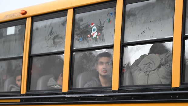 Children peek out bus windows as they arrive with a police escort  Saturday, Dec. 6, 2025, at Target in Allentown during Shop with an Airport Cop hosted by the Lehigh-Northampton Airport Authority Police Department. (Amy Shortell/The Morning Call)