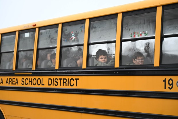 Children peek out bus windows as they arrive with a police escort  Saturday, Dec. 6, 2025, at Target in Allentown during Shop with an Airport Cop hosted by the Lehigh-Northampton Airport Authority Police Department. (Amy Shortell/The Morning Call)