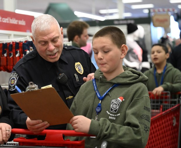 Johnathan Gaguski shops with Saturday, Dec. 6, 2025, with Officer John Mazzeo, a Lehigh-Northampton Airport Authority police officer, at Target in Allentown during Shop with an Airport Cop. (Amy Shortell/The Morning Call)