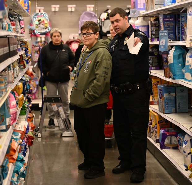 Lewis Sanchez- Hernandez shops with Saturday, Dec. 6, 2025, with Officer Troy Leonard, a Lehigh-Northampton Airport Authority police officer, at Target in Allentown during Shop with an Airport Cop.(Amy Shortell/The Morning Call)