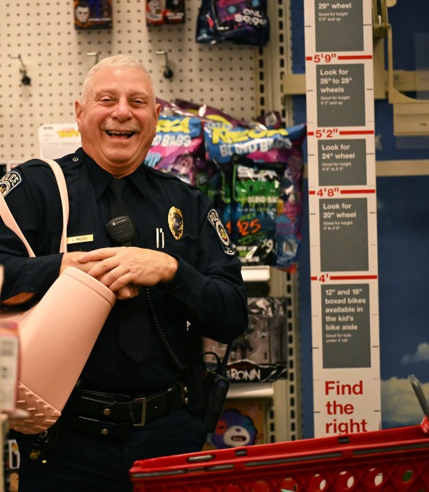 Officer John Mazzeo, a Lehigh-Northampton Airport Authority police officer, models a gift picked out by his partner for shopping Johnathan Gaguski at Target in Allentown during Shop with an Airport Cop. (Amy Shortell/The Morning Call)