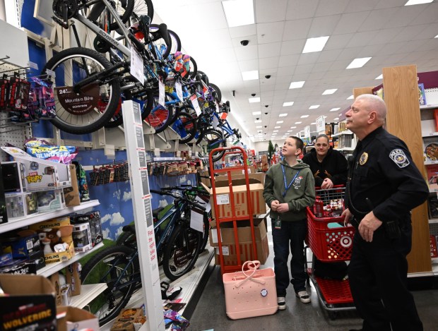 Johnathan Gaguski picks out a bicycle Saturday, Dec. 6, 2025, with Officer John Mazzeo, a Lehigh-Northampton Airport Authority police officer, at Target in Allentown during Shop with an Airport Cop.(Amy Shortell/The Morning Call)