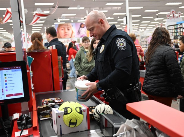Officer Ryan Heinrich checks out and loads gifts into a cart Saturday, Dec. 6, 2025, at Target in Allentown during Shop with an Airport Cop hosted by the Lehigh-Northampton Airport Authority Police Department. (Amy Shortell/The Morning Call)