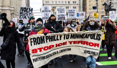 Protesters outside City Hall hold a banner reading FROM PHILLY TO MINNEAPOLIS STOP ICE TERROR