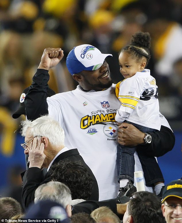 Steelers head coach Mike Tomlin carries his daughter Harley after winning Super Bowl XLIII