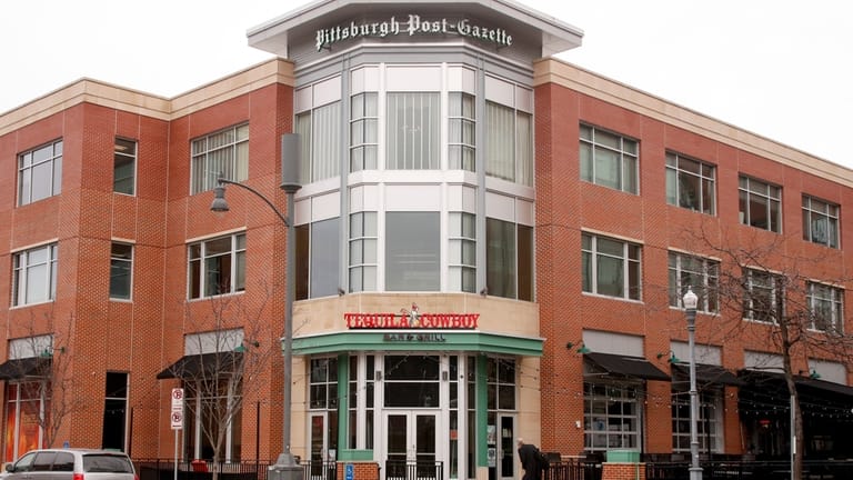 People walk past the building where the offices of the...