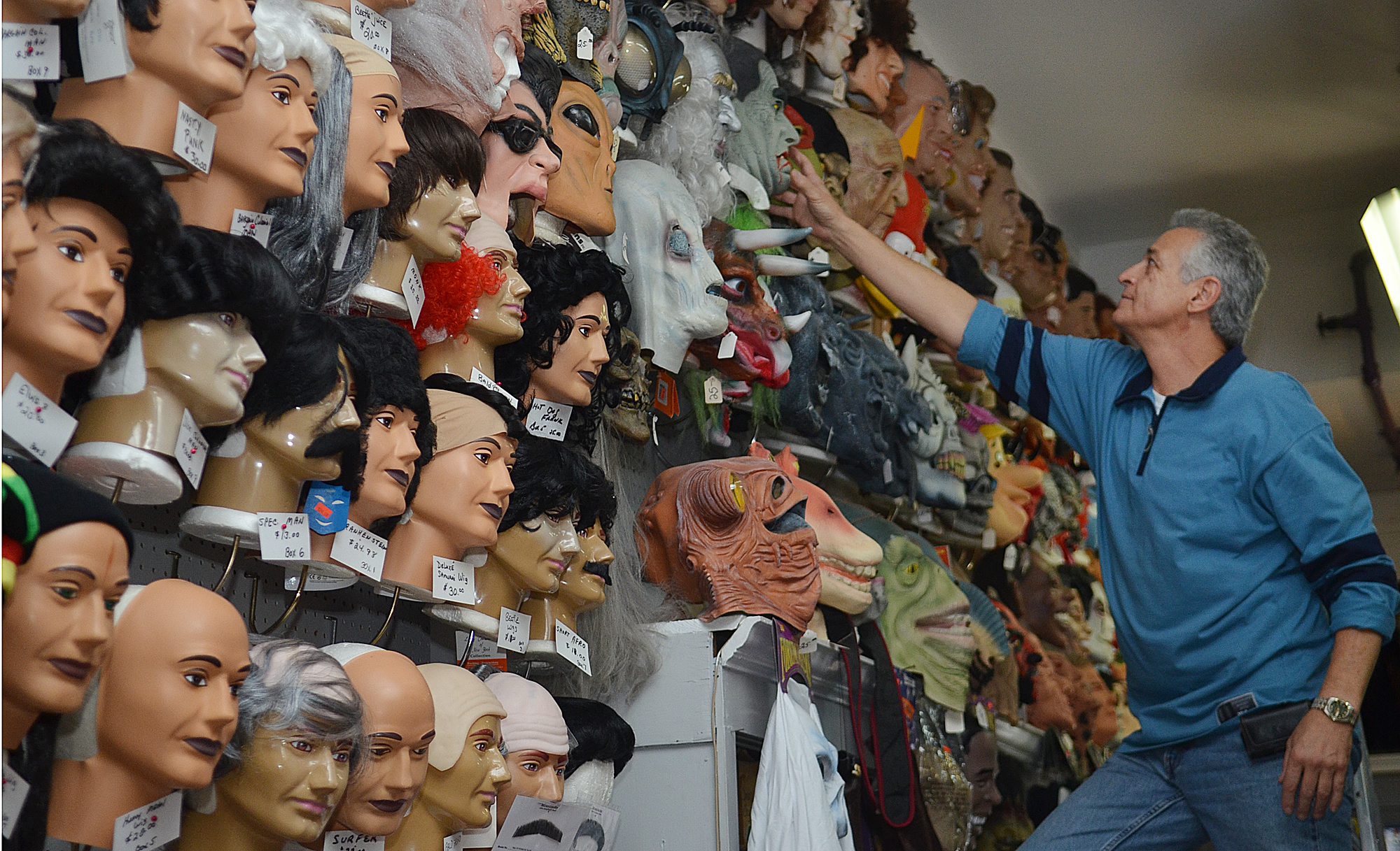James O’Hora, of Taney’s Costume Shop, uses a ladder to...