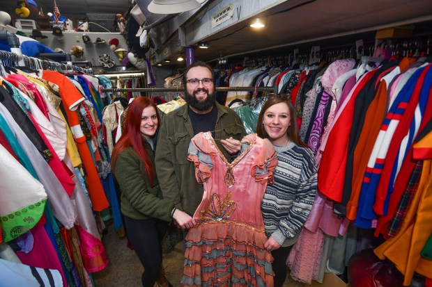 Business partners Allison Engle, Spencer Shotto, and Ashley Nole pose for a photograph with a costume that has been in Taney's Costume Shop in Scranton since it's opening over a century ago.