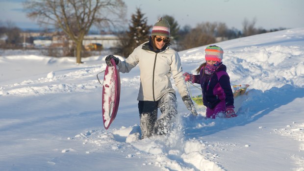 Cathy Wells and daughter Emma, 8, of Salisbury Township walk back toward their house Sunday, Jan. 24, 2016, after they gave up on sledding on almost 3 feet of snow on a hill at Alton Park off of Oxford Drive. The snow left by the Blizzard of 2016 was too deep. (Harry Fisher/the Morning Call)