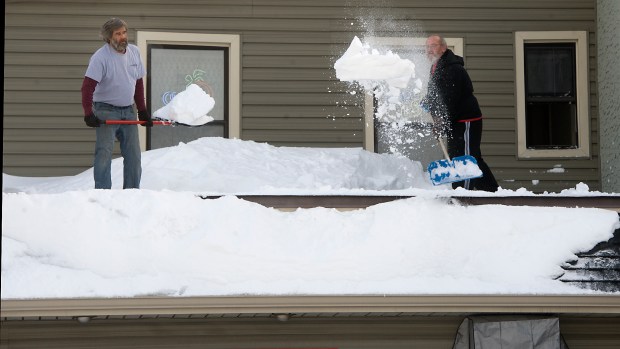 Tim Rosenberger (left) and David Rissmiller clear off snow from the roof over the bar of the Kuhnsville Hotel as Lehigh Valley residents recover from the Blizzard of 2016 on Jan. 25, 2016. (Harry Fisher/The Morning Call)