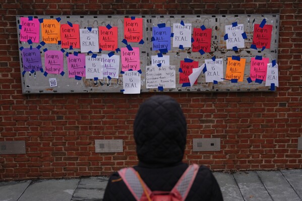 A person views posted signs on the locations of the now removed explanatory panels that were part of an exhibit on slavery at President's House Site in Philadelphia, Friday, Jan. 23, 2026. (AP Photo/Matt Rourke)