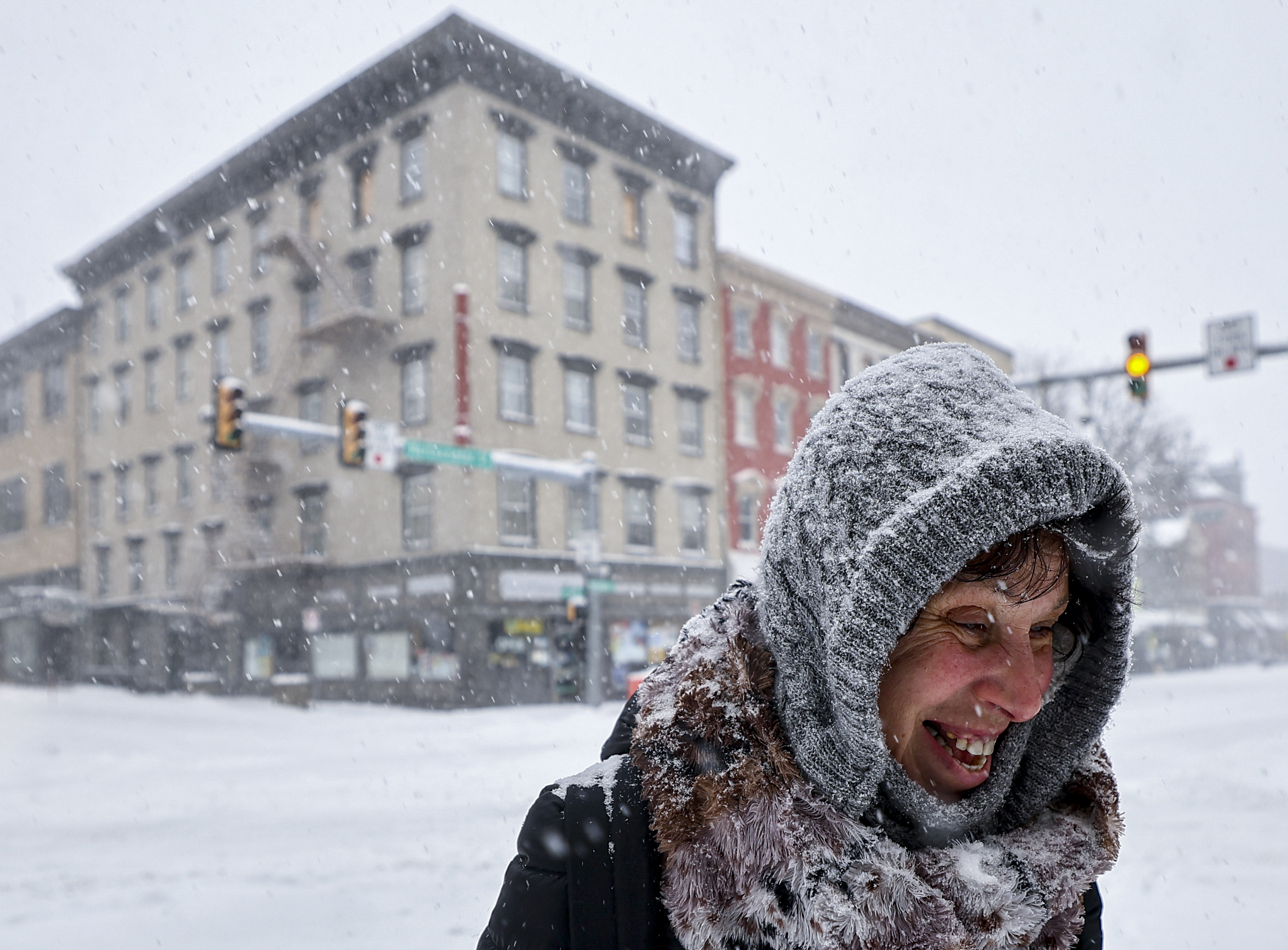 Covered in snow, Sonjia Labriola, of Easton, is all smiles after carefully crossing Northampton Street about 11:05 a.m. as she heads home from shopping Sunday, Jan. 25, 2026.