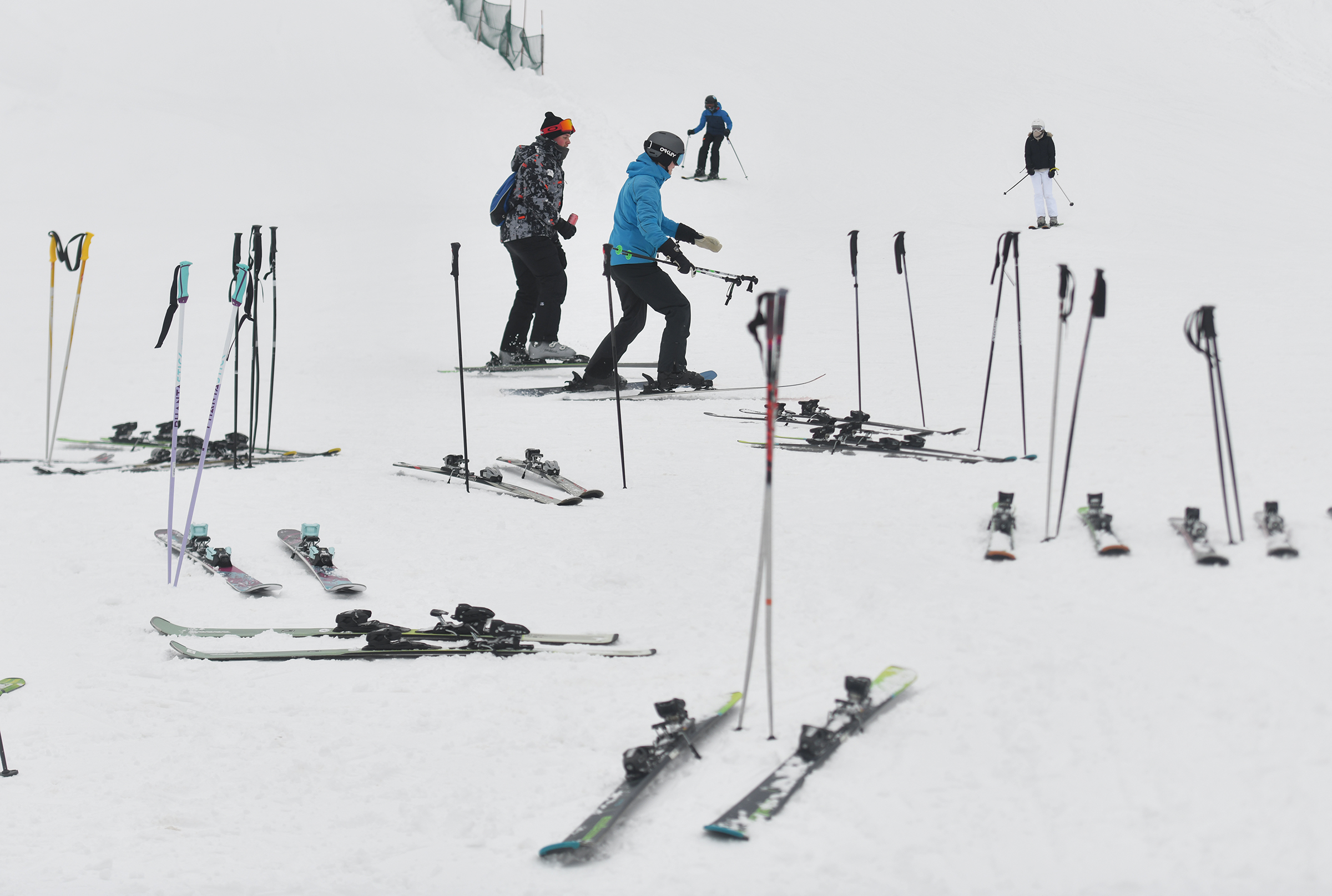 Skiiers walk to the ski lifts to go up the...