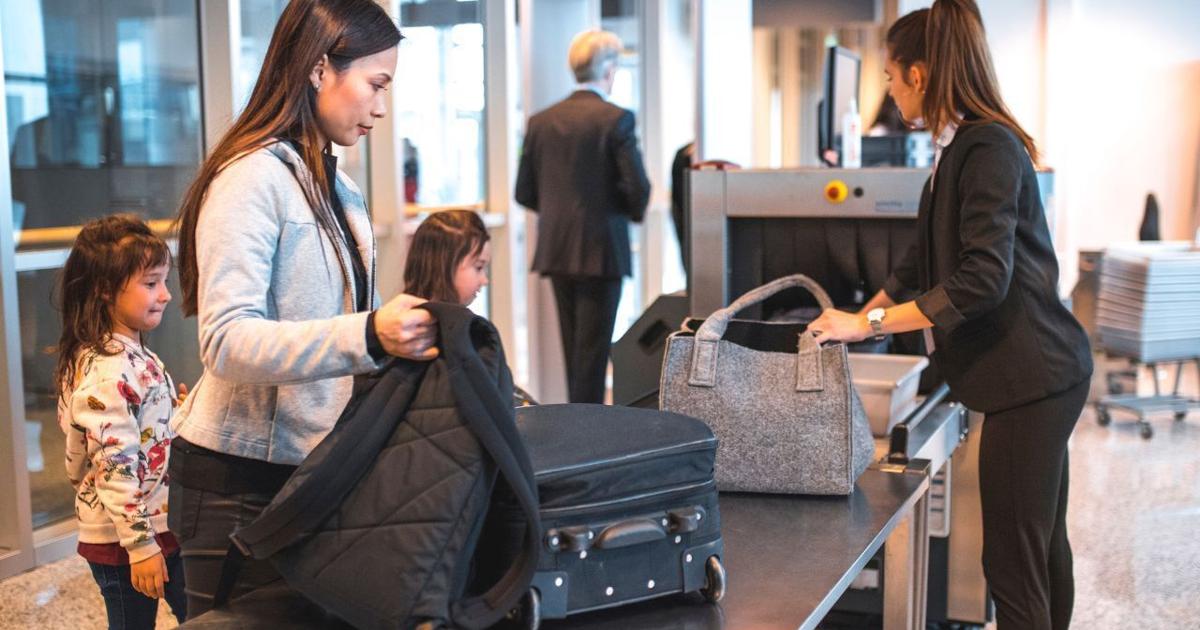 Mom and daughters at airport security screening | Travel