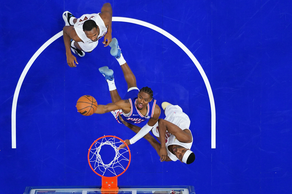 Philadelphia 76ers' Tyrese Maxey, center, goes up for a shot between Cleveland Cavaliers' Nae'qwan Tomlin, right, and Evan Mobley during the second half of an NBA basketball game Wednesday, Jan. 14, 2026, in Philadelphia. 