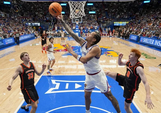 Nov 15, 2025; Lawrence, Kansas, USA; Kansas Jayhawks guard Tre White (3) shoots against Princeton Tigers guard Jackson Hicke (33) and guard Landon Clark (8) during the second half at Allen Fieldhouse.