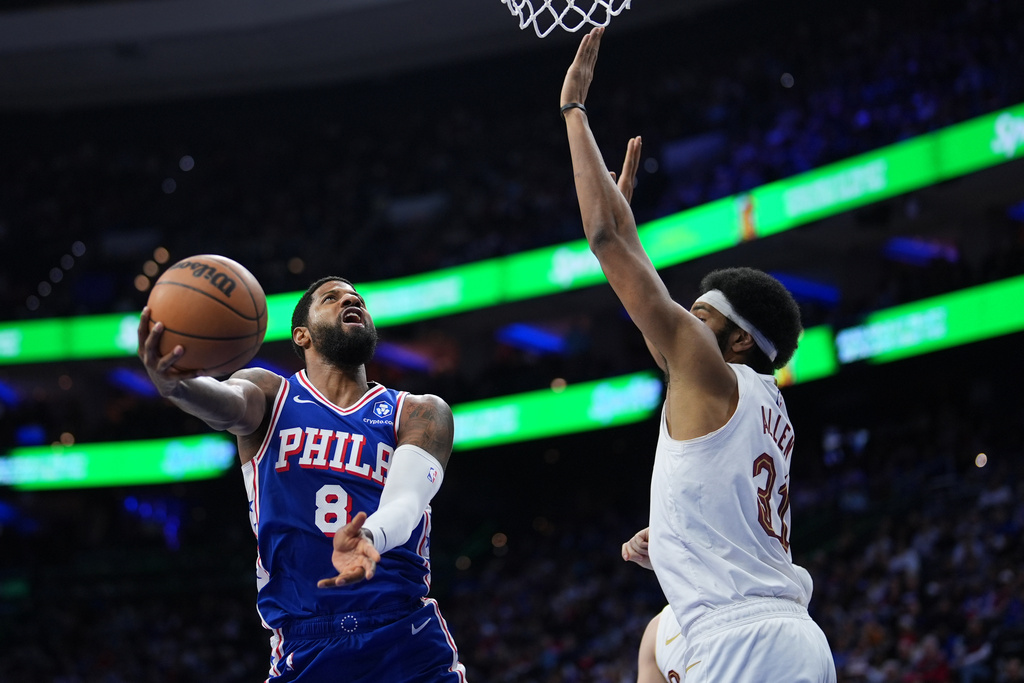 Philadelphia 76ers' Paul George, left, goes up for a shot against Cleveland Cavaliers' Jarrett Allen during the first half of an NBA basketball game Wednesday, Jan. 14, 2026, in Philadelphia.